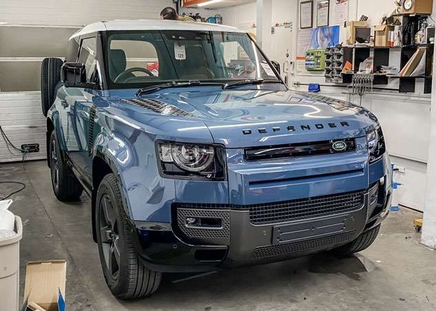 Blue Land Rover Defender with white roof