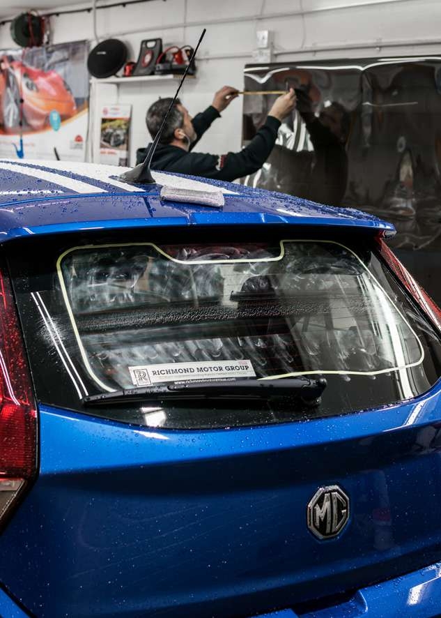 Blue MG3 car rear window being prepared for window tinting