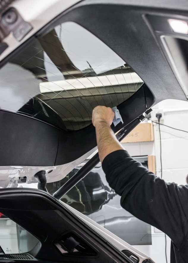 Rear window being tinted using LLumar window tinting film on White BMW X5
