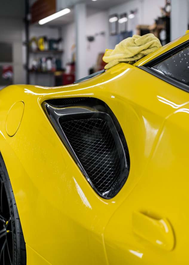 Paint protection film (PPF) applied to side intake of yellow Ferrari 488 Pista