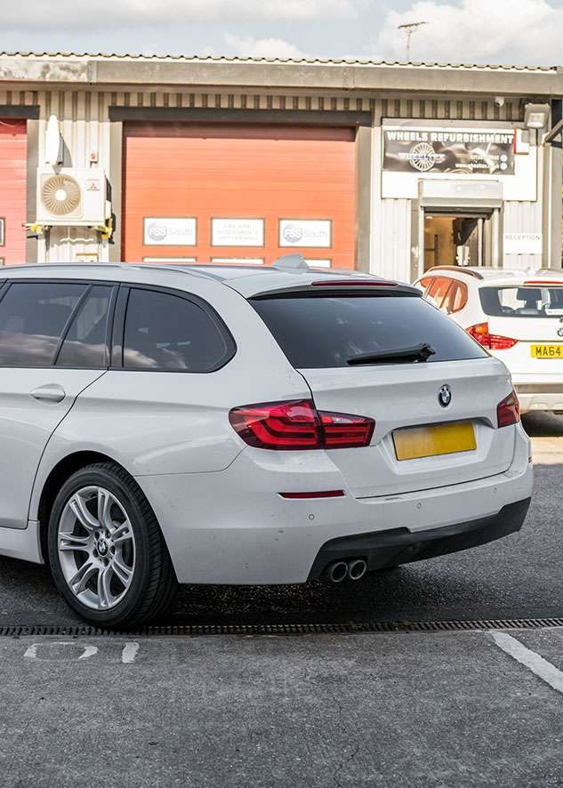White BMW 5 series with tinted windows from rear