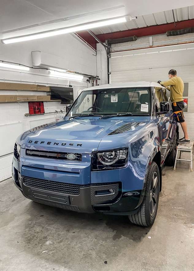 White vinyl wrap applied to roof of Blue Land Rover Defender