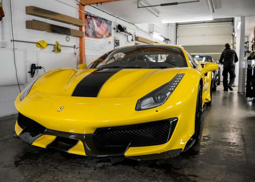 Car in studio/garage yellow Ferrari 488 Pista after paintwork protection, paint protection film (PPF) and ceramic coating application.