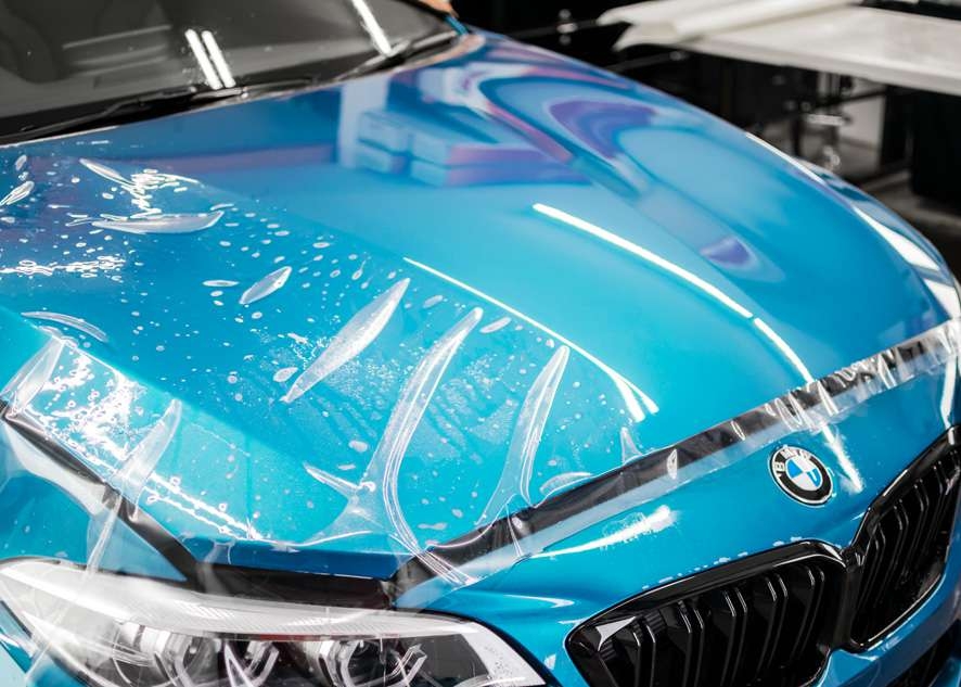 Paint protection film (PPF) being applied to bonnet/hood of blue BMW M2C