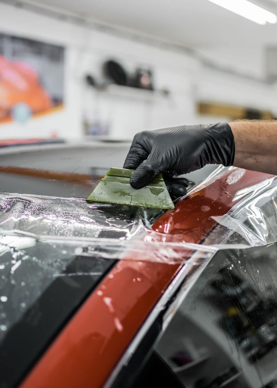 Paint protection film being applied to car