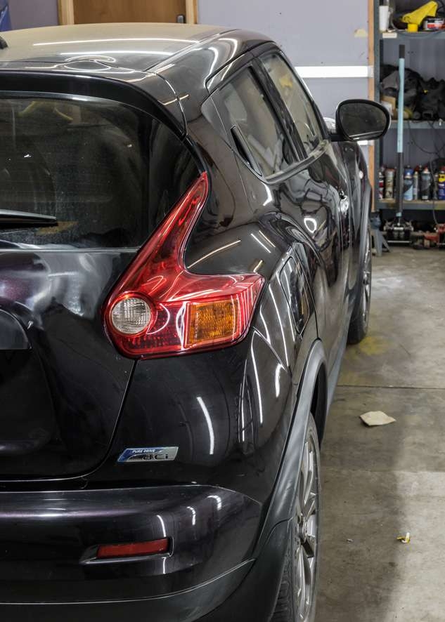 Side shot of black Nissan Juke car with dull paintwork before polishing