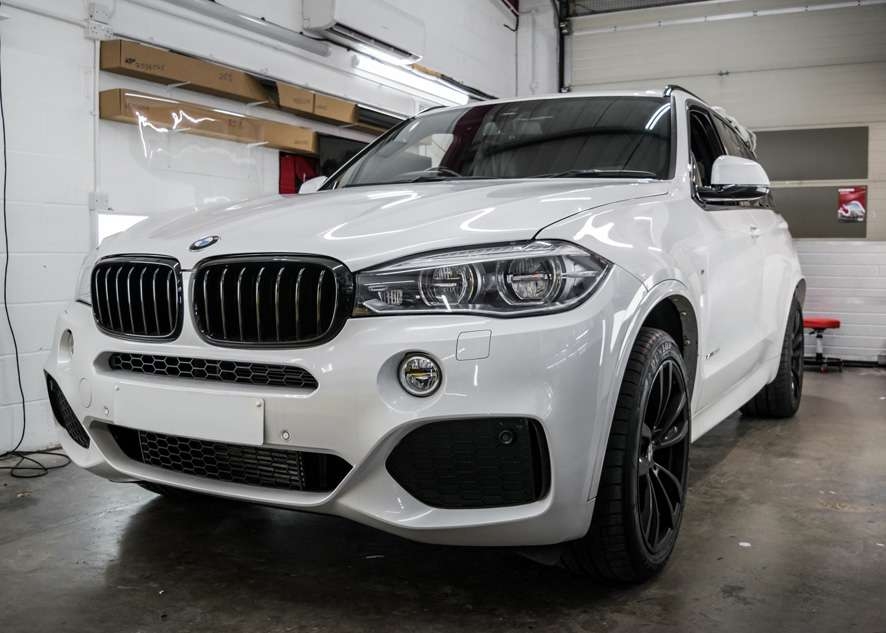 White BMW X5 during window tinting