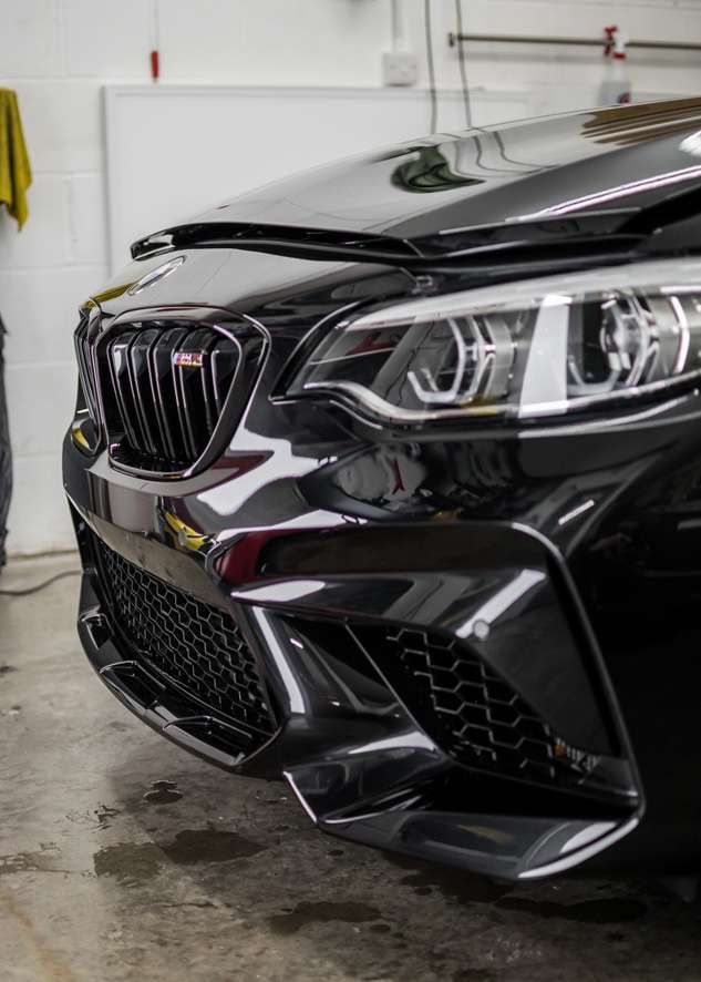 Front of black BMW M2C before paint protection film (PPF)