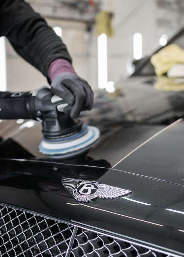 Bentley Flying Spur car being professionally polished using best equipment in glove