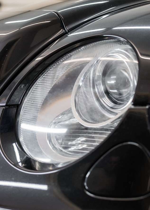 Close up shot of right side Bentley Flying Spur cloudy/foggy headlight before headlight restoration