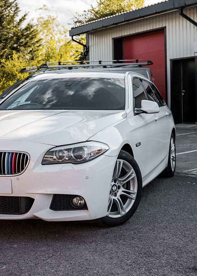 Front side shot of white BMW 5 series with tinted windows